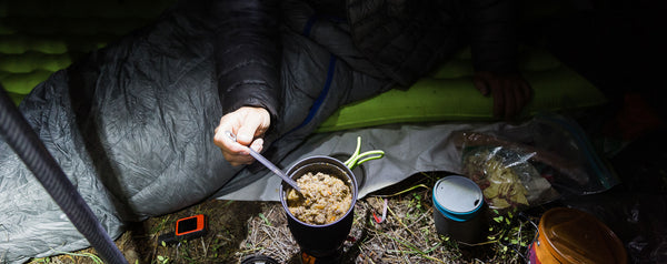 Eating backcountry meal in tent