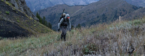 hunter hiking in mountains with synthetic insulation jacket